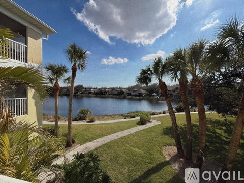 A view of a lake from a balcony with palm trees.