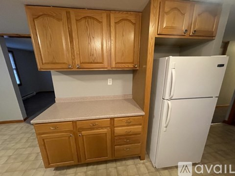 A kitchen with wooden cabinets and a white refrigerator.