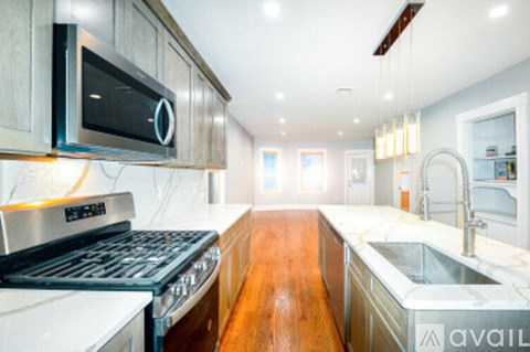 A modern kitchen with a stove top oven and a microwave above it.