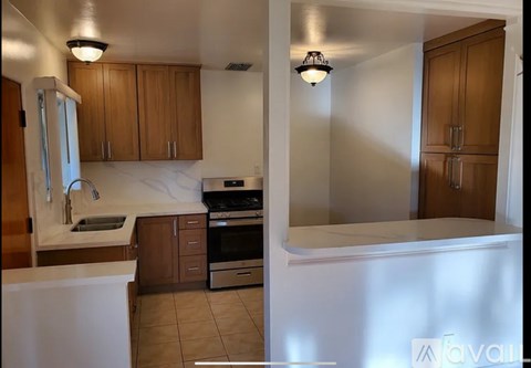 A kitchen with white countertops and wooden cabinets.