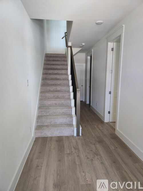A staircase with a carpeted runner and wooden steps leads up to a doorway.