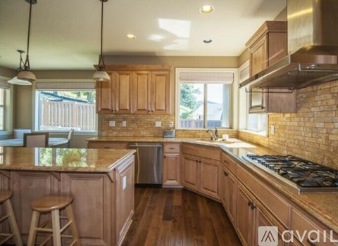 A kitchen with wooden cabinets and a brick wall backsplash.