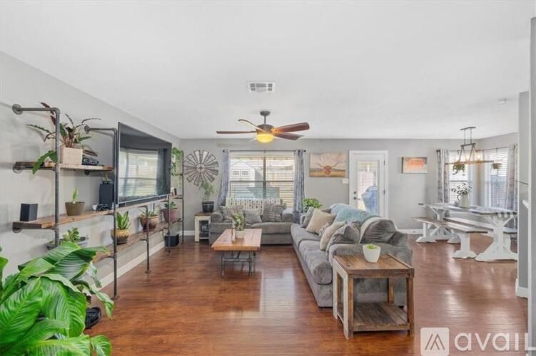 A living room with a couch, a coffee table, and a ceiling fan.