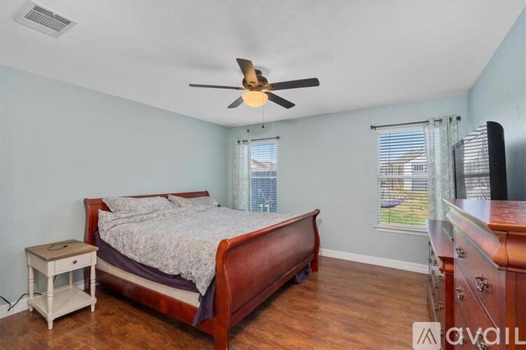 A bedroom with a bed, nightstand, and dresser.
