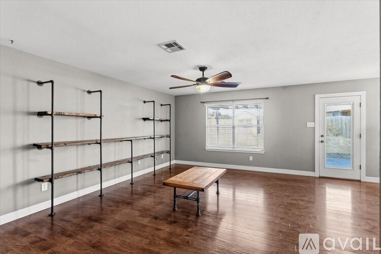 A hallway with a wooden door and a sign on the wall.