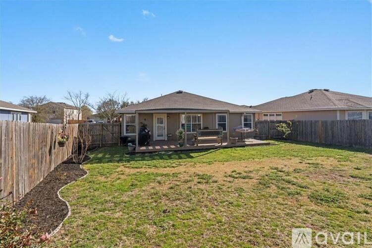A house with a brown roof and a fence in front of it.