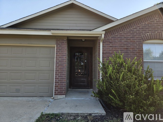A house with a brown door and a grey garage door.