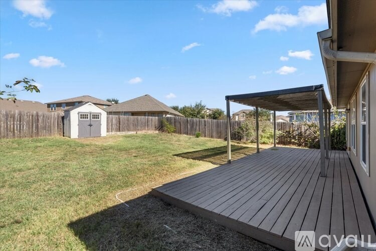 A wooden deck leads to a covered patio area.