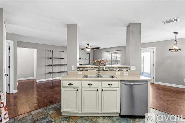 A kitchen with white cabinets and a tile floor.