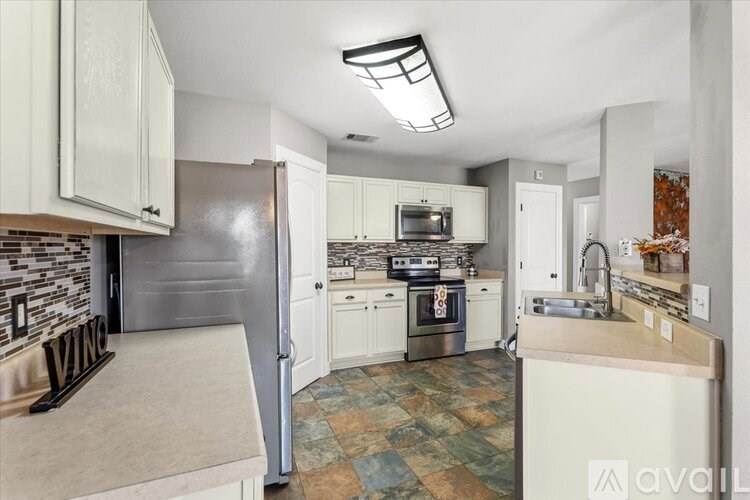 A wooden deck with a bench and potted plants under a roof.