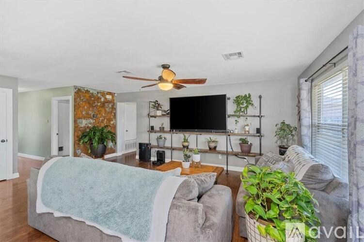 A living room with a grey couch and a blue blanket on it.