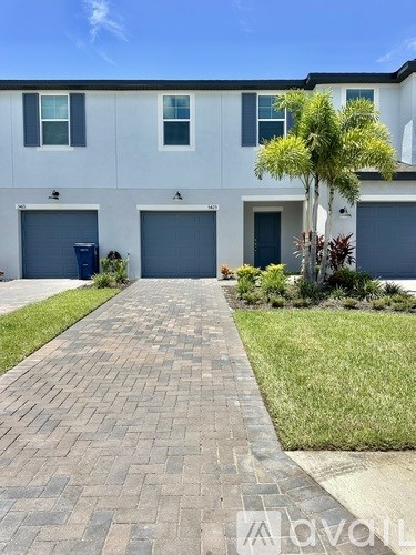 A white two-story house with a driveway in front.
