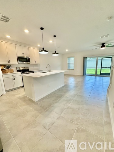 A kitchen with white cabinets and a large island.