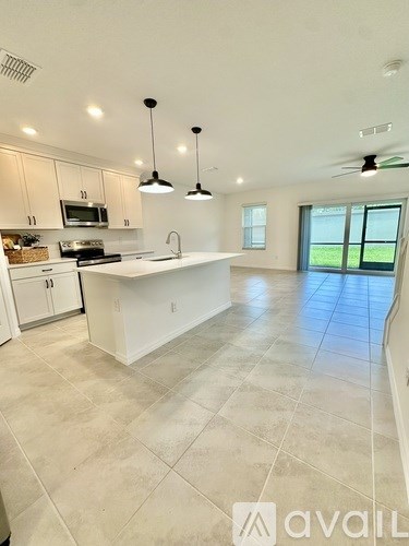 A kitchen with white cabinets and a large island.
