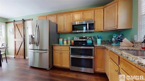 A kitchen with wooden cabinets and a stainless steel refrigerator.