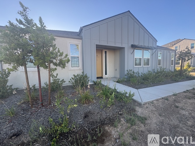 A modern house with a grey exterior is available for purchase.