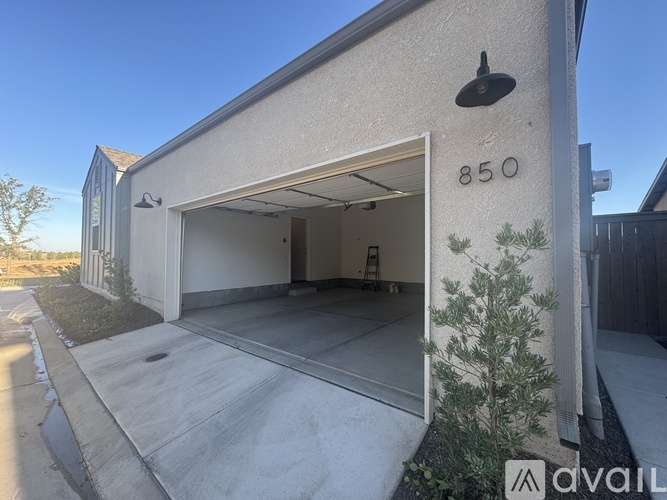 A house numbered 850 with a garage door open.