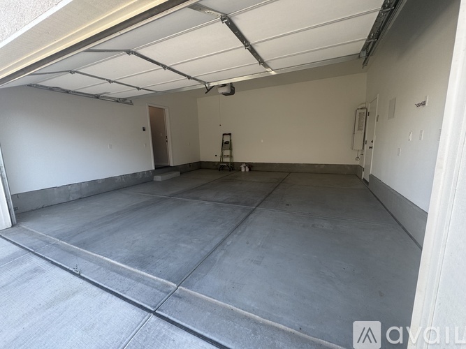 A spacious garage with a concrete floor and white walls.