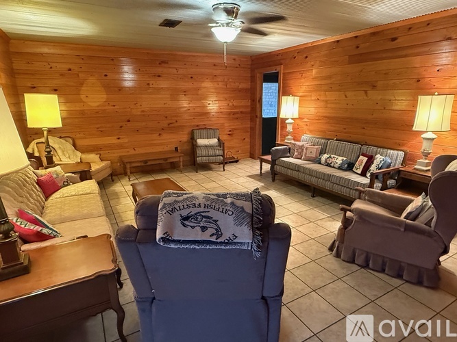 A living room with a blue chair and a grey couch.