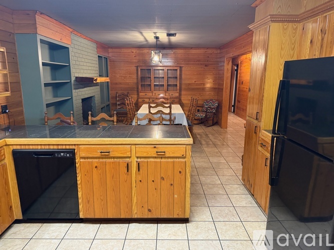 A kitchen with wooden cabinets and black appliances.