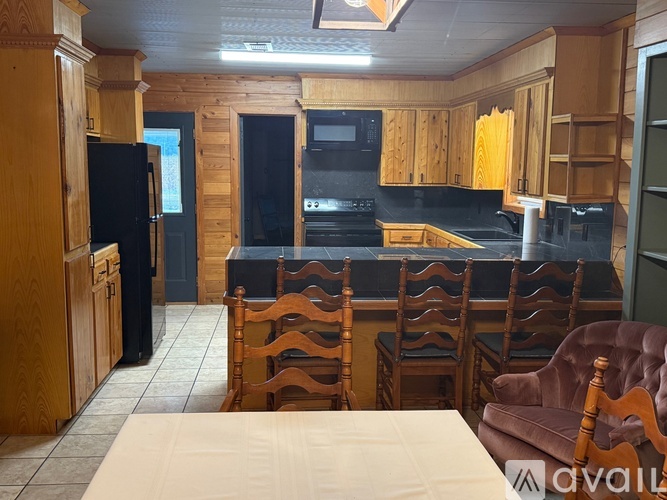 A kitchen with wooden cabinets and black appliances.