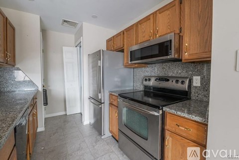A kitchen with wooden cabinets and stainless steel appliances.