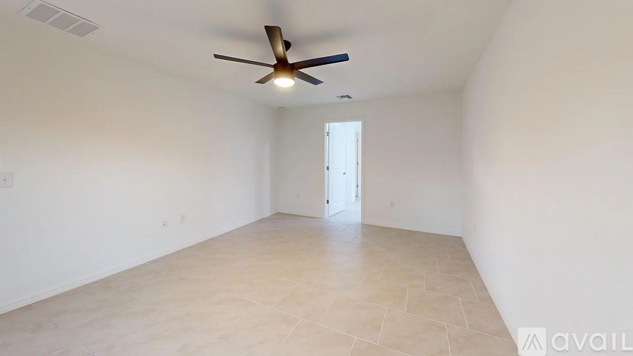 A room with a ceiling fan and a door.