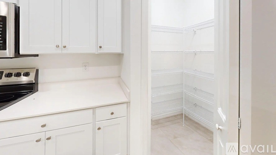 A kitchen with white cabinets and appliances.