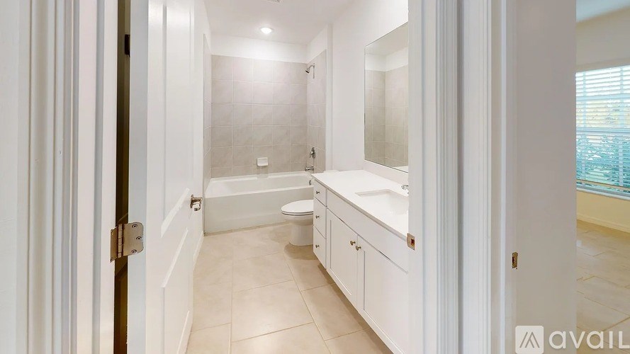 A bathroom with a toilet, sink, and bathtub.