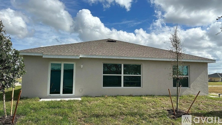 A house with a brown roof and white walls is for sale.