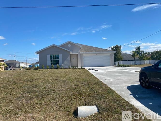 A house with a garage and a driveway in front of it.