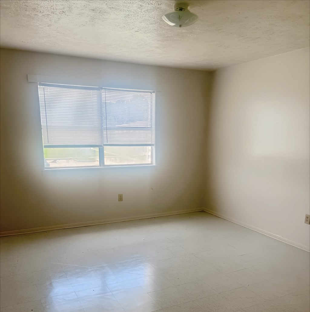 A room with a window and a ceiling fan.