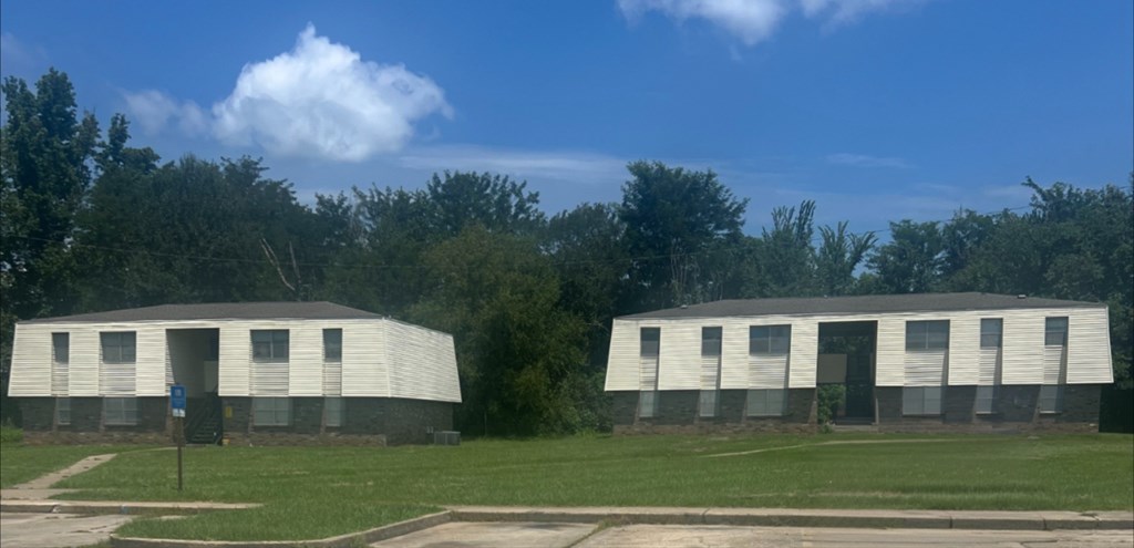 Two identical buildings are situated in a grassy field.
