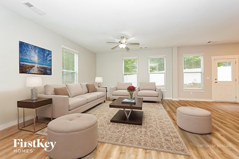 A living room with a couch, a coffee table, and a painting on the wall.