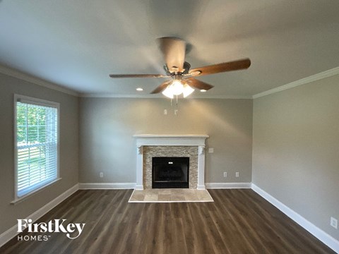 A room with a fireplace and a ceiling fan.