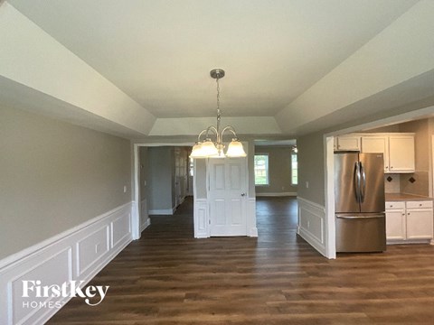 A large open kitchen and living room with wood floors and white walls.