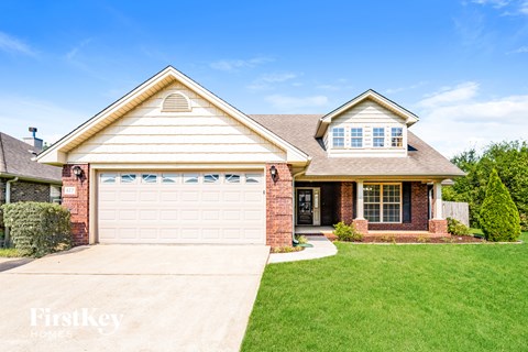 A house with a garage and a driveway in front.