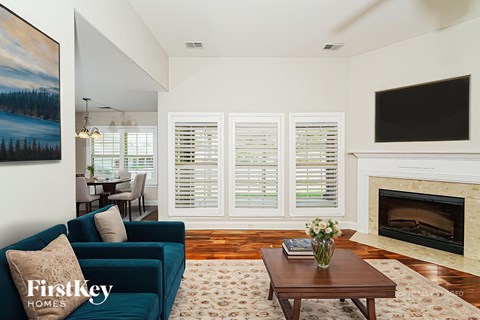 A living room with a blue couch and a fireplace.