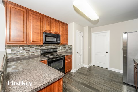 A kitchen with wooden cabinets and a granite countertop.
