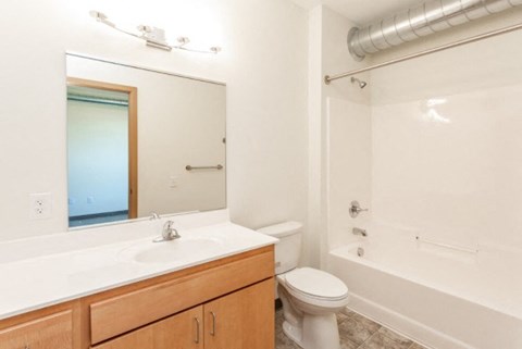 A white bathroom with a toilet, sink, and bathtub.