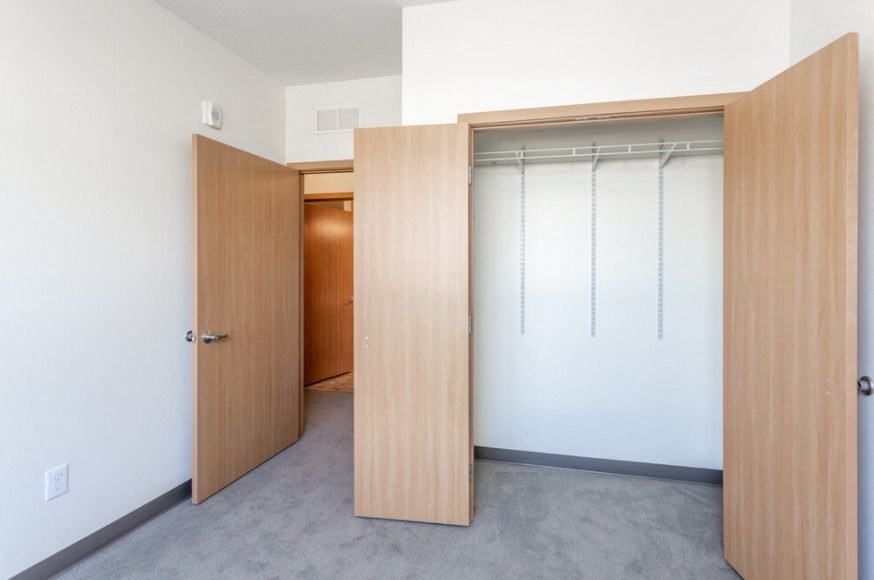 A room with a white wall and a brown door.