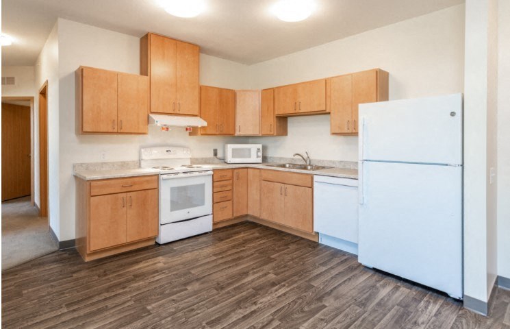 A kitchen with wooden cabinets and a white refrigerator.