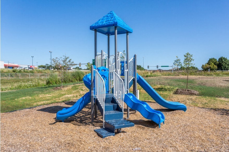 A playground with a blue slide and tower.