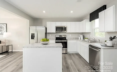 A modern kitchen with white cabinets and a large island.