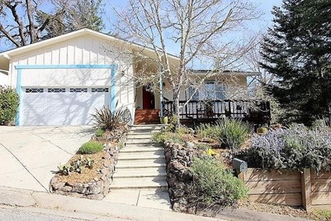 A house with a white garage door and a brown fence.