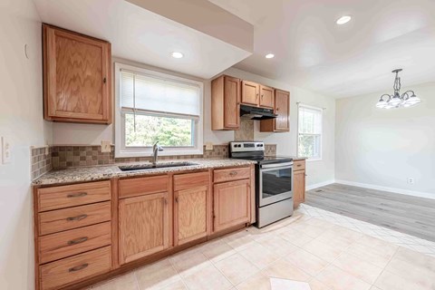 A kitchen with wooden cabinets and a granite countertop.