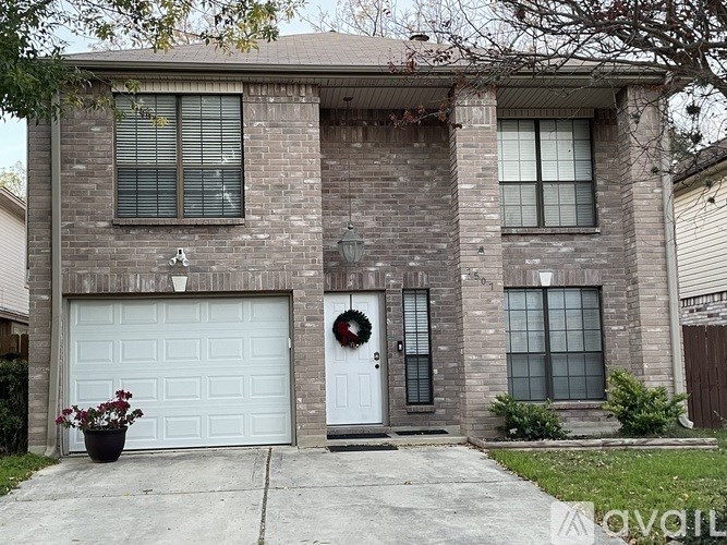 A house with a white garage door and a wreath on the door.