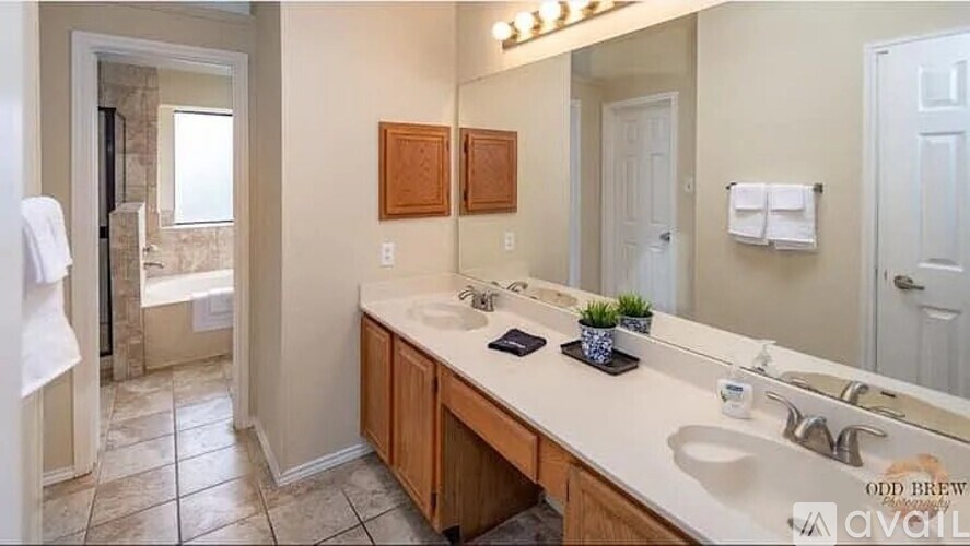 A bathroom with a large mirror and a white sink.