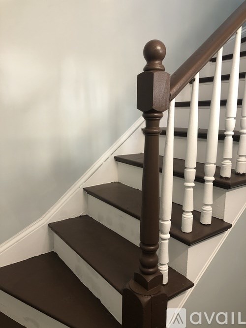 A staircase with white risers and dark brown treads.