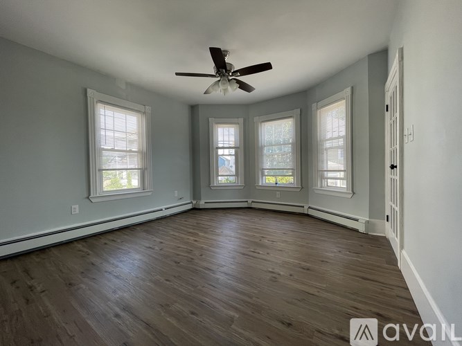 A room with wooden floors and a ceiling fan.